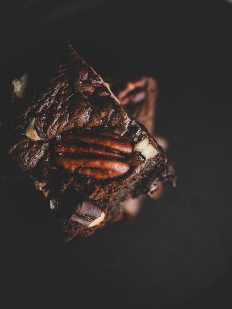 Dettaglio di brownie al cioccolato con noci pecan e granelli di fleur de sel.