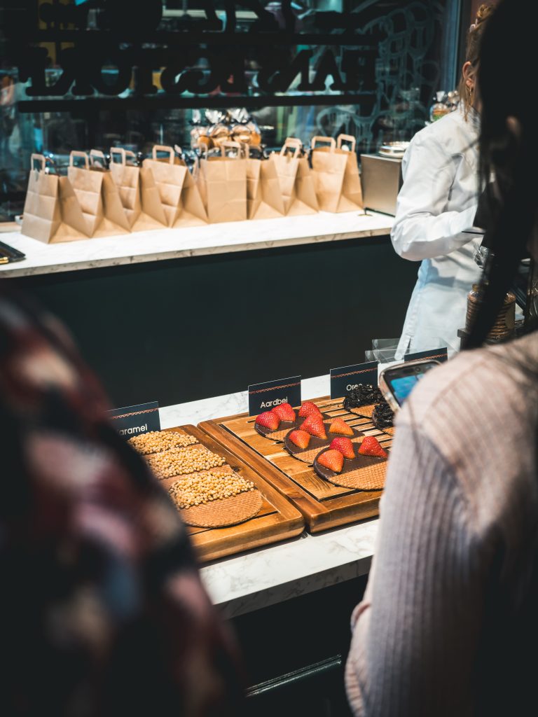 Banco di waffle artigianali in una bakery di Amsterdam con fragole fresche, cioccolato e topping croccanti.