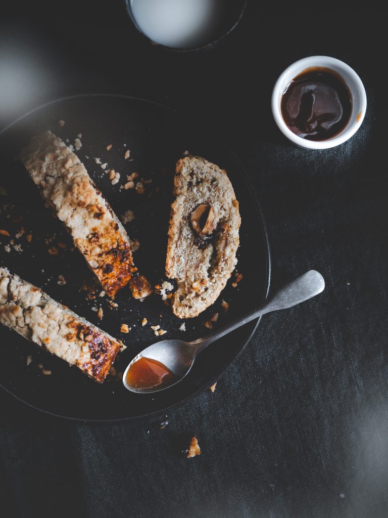 Biscotti rustici all’avena e nocciole fotografati in luce naturale con atmosfera moody e domestica.