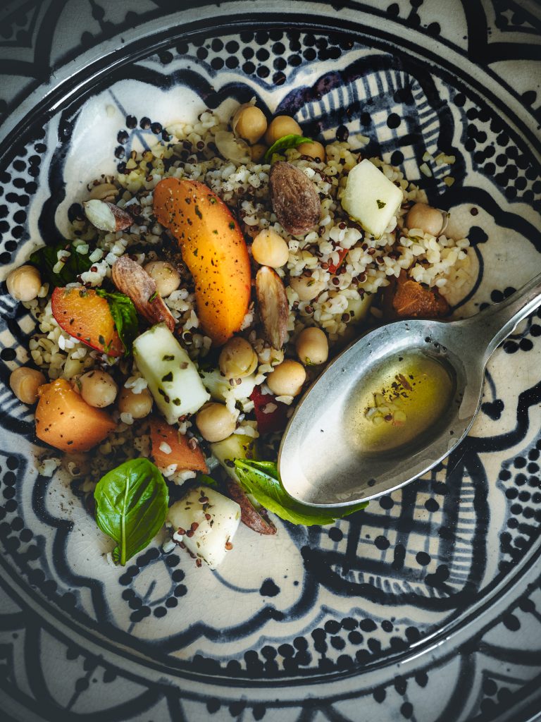 Dettaglio di insalata di bulgur e quinoa con albicocche, ceci, barattiere e mandorle tostate