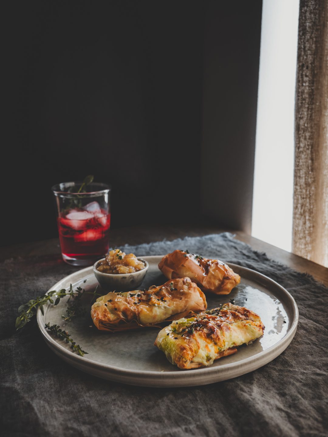 Saccottini di pasta phyllo ai fiori di zucca con ricotta, scamorza e composta di pere coscia serviti con aperitivo.