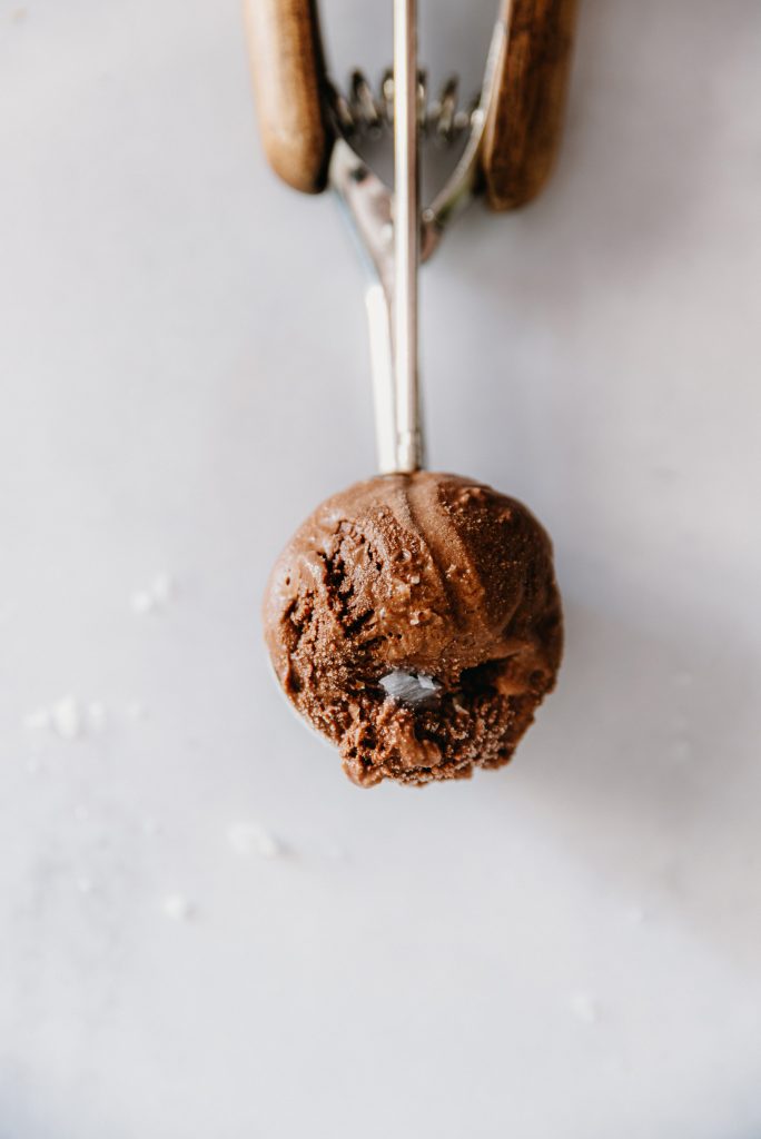 Pallina di gelato fondente al cioccolato vista dall’alto, cremosa e cosparsa con pochi cristalli di sale