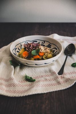Minestra tiepida di zucchine, patate e carote con riso e cipolla croccanti e olio al basilico.